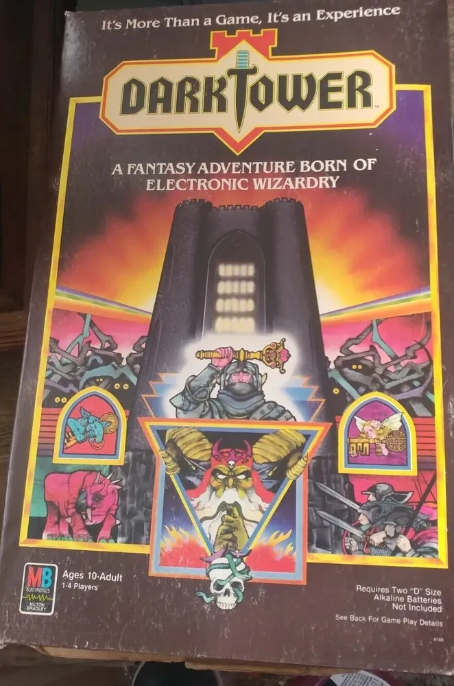 Box cover art for the electronic board game "Dark Tower" featuring a looming black tower against a red sky, surrounded by images of fantastical creatures and warriors. Text indicates it as a fantasy adventure game for ages 10 to adult, requiring two "D" size batteries.