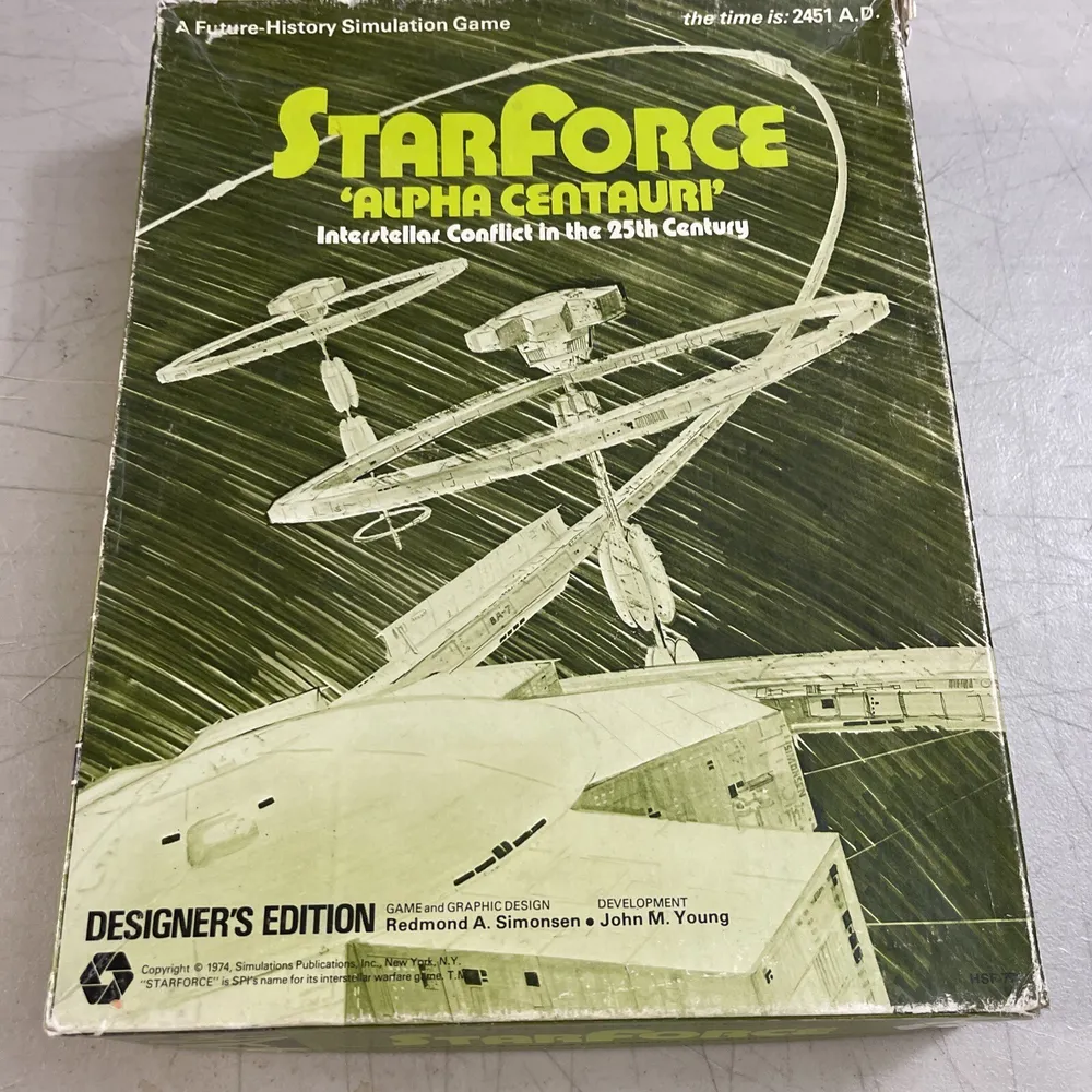 A worn box cover of "STARFORCE ALPHA CENTAURI: A Future-History Simulation Game", featuring stylized spaceship illustrations and labeled as "Designer's Edition".