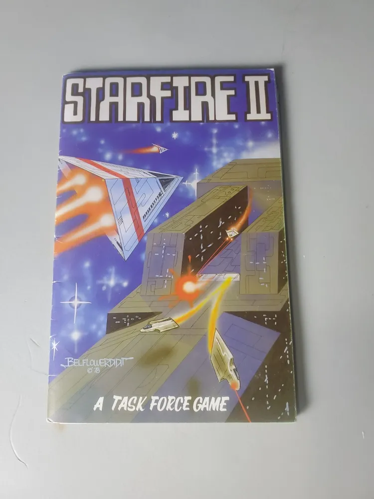 "Starfire II" game booklet with space-themed artwork featuring spacecraft and a tagline reading "A TASK FORCE GAME", displayed on a white surface.