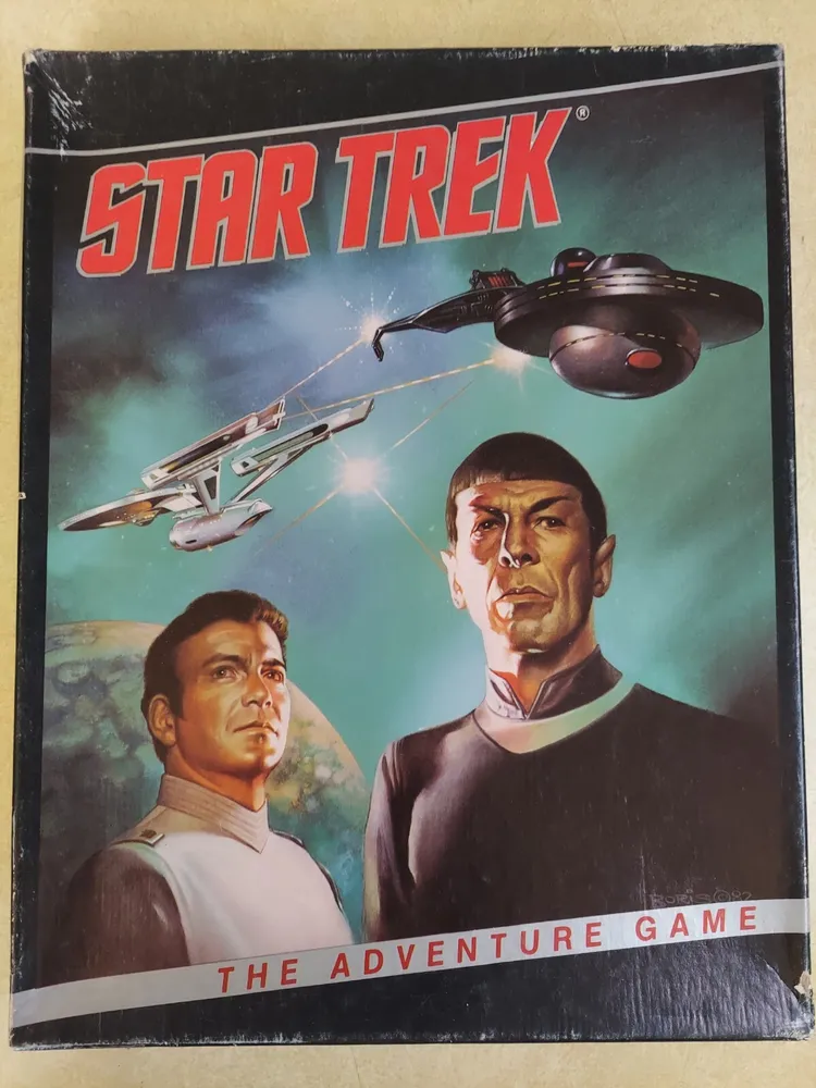 A vintage Star Trek board game cover featuring illustrations of two characters in uniform, a spaceship battle in space, and the text "STAR TREK THE ADVENTURE GAME."