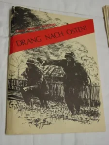 A photo of a book cover with the title "Drang Nach Osten!" in red lettering, featuring a black and white illustration of two soldiers walking past a wooden fence.