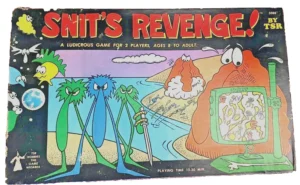 The image shows the cover of a vintage board game titled "SNIT'S REVENGE!" by TSR. It is described as a ludicrous game for 2 players, ages 8 to adult. The cover features colorful cartoon illustrations of quirky alien creatures and includes a graphic showing the game's playtime of 15-30 minutes. The cover shows signs of wear and tear, with a corner slightly damaged.