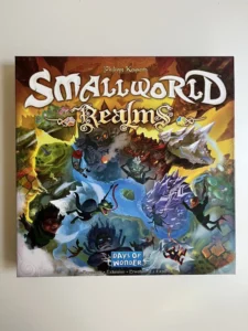 Box front cover of "Small World Realms" board game by Days of Wonder featuring colorful fantasy artwork with various mythical creatures and characters.