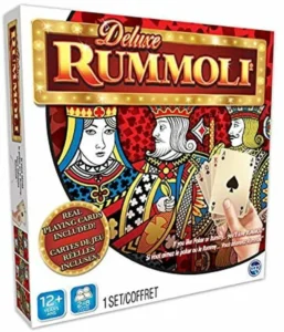 Box cover for the board game "Deluxe Rummoli" featuring playing card king and queen illustrations, and including real playing cards. Suitable for ages 12+, for 2-8 players.