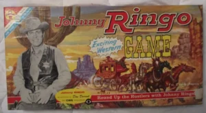 Vintage "Johnny Ringo Game" board game box featuring a monochrome image of a cowboy with a hat and a vest, and colorful illustrations of a Western landscape with a stagecoach and horses. The text indicates it's an "Exciting Western Game" for "2 to 6 players" and references the character Johnny Ringo as portrayed by Don Durant on CBS television.