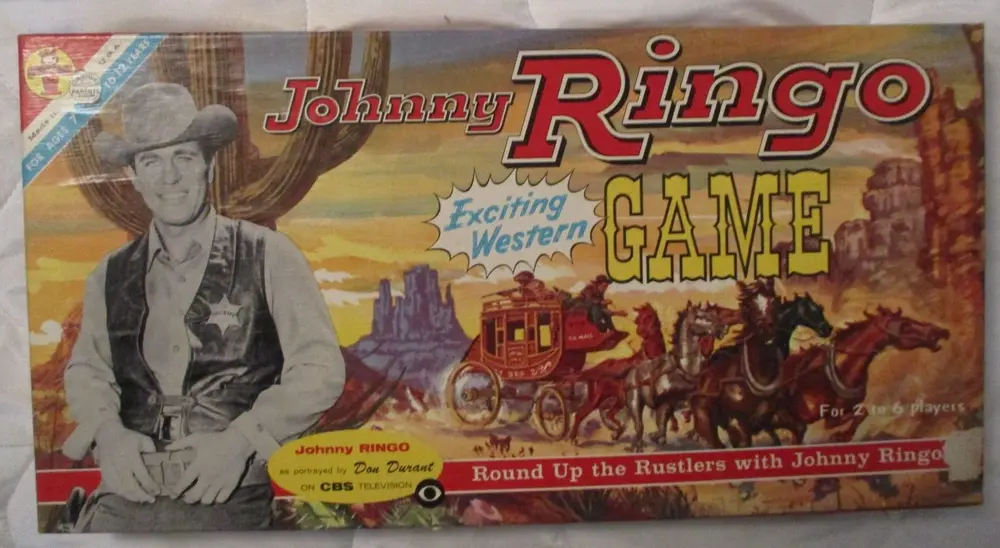 Vintage "Johnny Ringo Game" board game box featuring a monochrome image of a cowboy with a hat and a vest, and colorful illustrations of a Western landscape with a stagecoach and horses. The text indicates it's an "Exciting Western Game" for "2 to 6 players" and references the character Johnny Ringo as portrayed by Don Durant on CBS television.