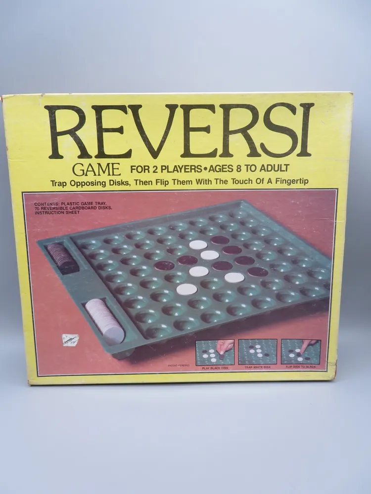 Box of the "Reversi" board game for two players aged 8 to adult, featuring an image of the game in progress with reversible disks on the front cover.