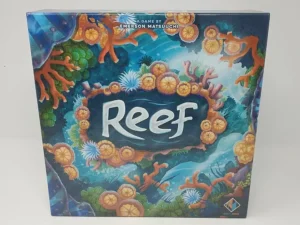Board game titled "Reef" with a colorful underwater coral theme on the cover, designed by Emerson Matsuuchi and produced by Next Move Games.