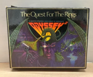 A worn box cover for "The Quest For The Rings", a master strategy video game by Magnavox Odyssey², featuring fantasy artwork with dragons and a warrior.