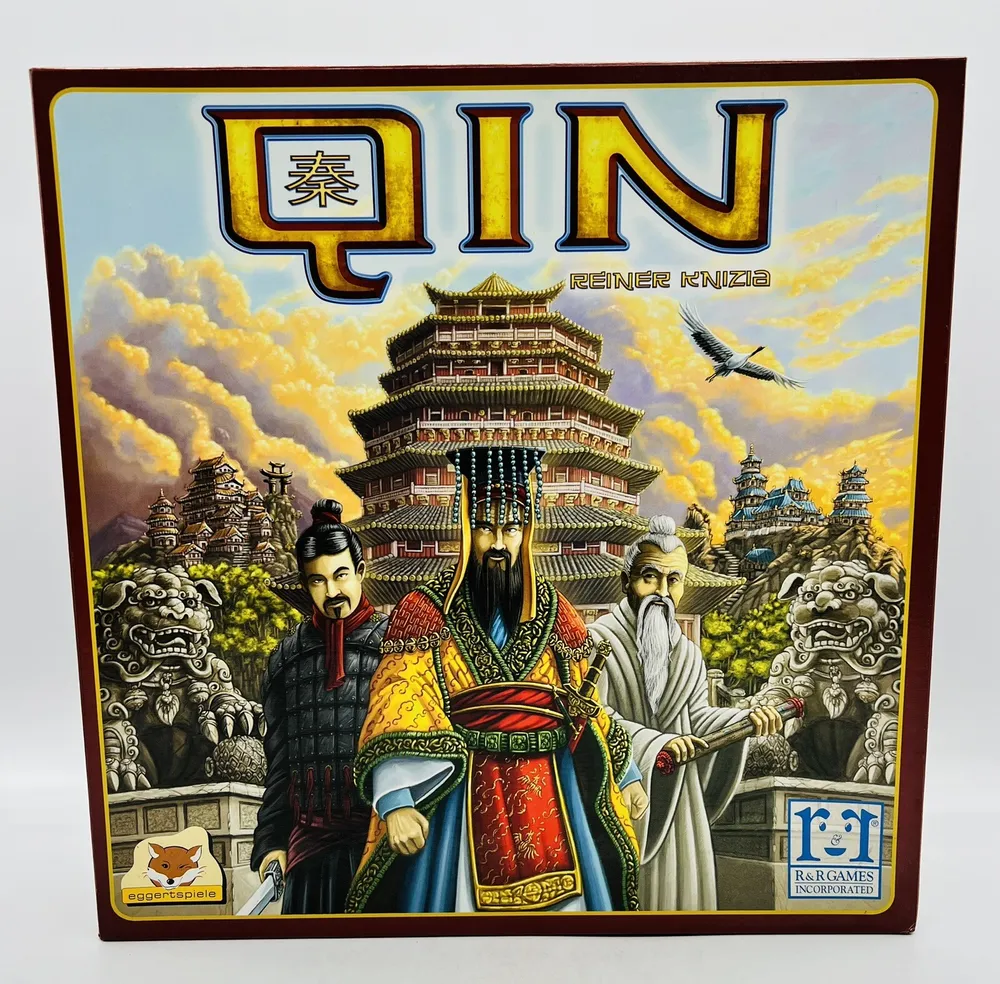 Board game cover for "QIN" featuring stylized artwork with three ancient Chinese figures in traditional attire in front of a pagoda, clouds, and stone lion guardians, with the name "Reiner Knizia" and logos of "eggertspiele" and "R&R Games Incorporated."