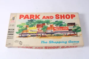 Vintage Milton Bradley "PARK AND SHOP" board game box with colorful mid-century artwork depicting a shopping street scene, labeled as "The Shopping Game," for ages 10 to adult.