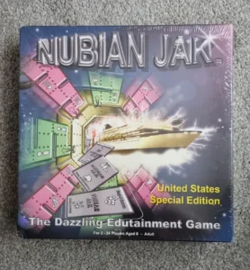A sealed board game titled "NUBIAN JAK," United States Special Edition, described as "The Dazzling Edutainment Game" for 2-24 players aged 8 and above, featuring colorful board pieces and cards on the cover.