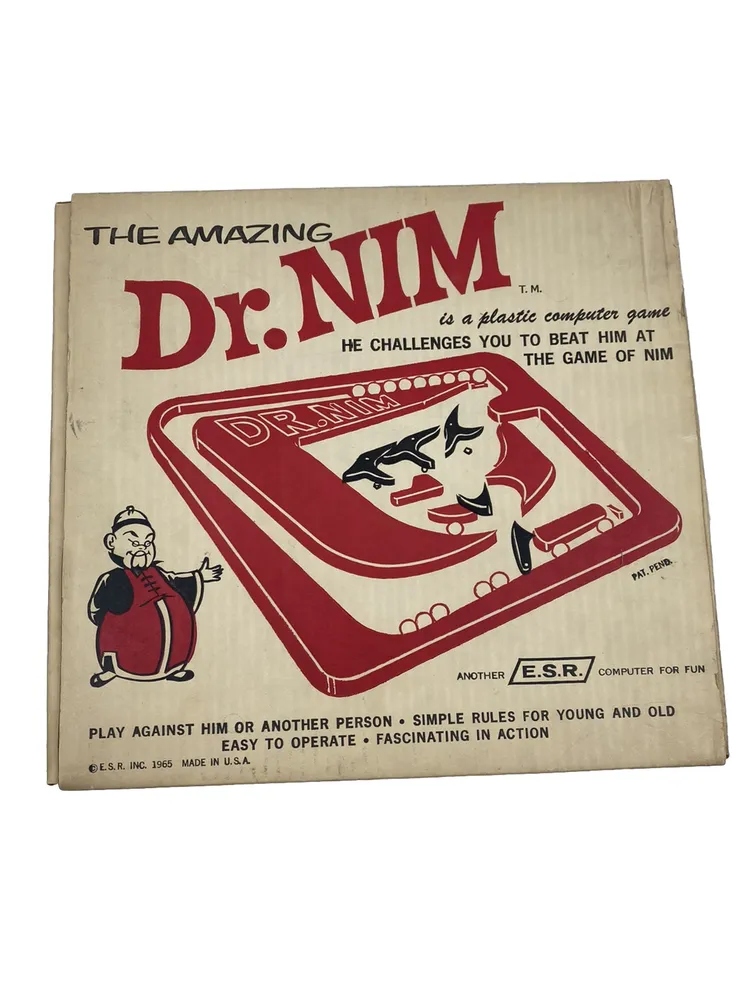 Vintage box cover of "The Amazing Dr. NIM" game, featuring a cartoon man in a red robe and a playful depiction of the game with marbles and levers, with text describing it as a plastic computer game where you try to beat the game at Nim. Marked as made by E.S.R. INC. in 1965, USA.