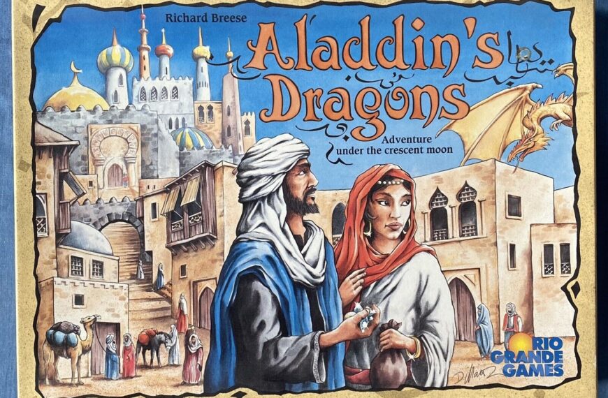 The image shows the cover of a board game titled "Aladdin's Dragons" by Richard Breese, depicting a colorful, illustrated scene with a Middle Eastern cityscape and a man and woman in traditional clothing in the foreground. There is a dragon flying in the sky above the city, and the text mentions an "Adventure under the crescent moon." The Rio Grande Games logo is displayed in the bottom right corner.