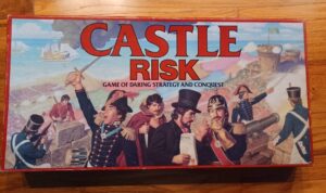 The image shows the box cover of the "CASTLE RISK" board game, featuring illustrated characters in historical military uniforms from various cultures, engaging in battle and strategy, with sailing ships in the background and a castle atop a hill with a raised flag.