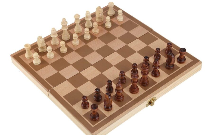 A wooden chessboard with all the chess pieces in the starting position, isolated on a white background.