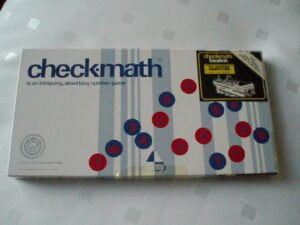 A checkmath board game box with red and blue numbered circles scattered across its surface and a small yellow sticker on the top right promoting a competition.