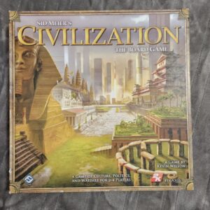 Board game cover for "Sid Meier's Civilization: The Board Game" depicting a blend of ancient and modern architectural wonders, with a partially visible Great Sphinx, a city skyline, ancient Southeast Asian temples, and East Asian traditional buildings, along with text indicating a game of culture, politics, and warfare for 2-4 players by Kevin Wilson, published by 2K and Firaxis.