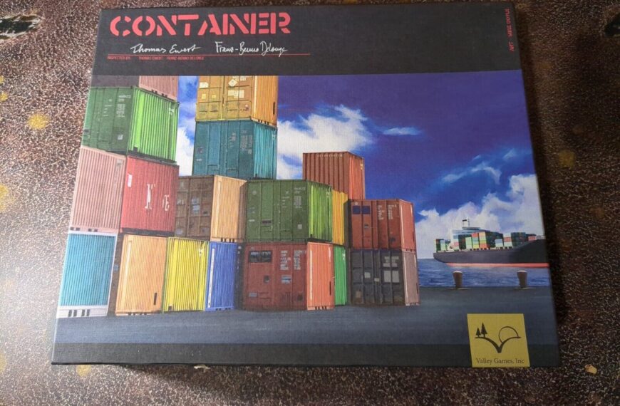 A board game titled "CONTAINER" is lying on a textured surface, with an illustration on the cover showing colorful shipping containers stacked on a dock with a cargo ship and blue sky in the background. The game is by Thomas Ewert and Franz-Benno Delonge, published by Valley Games, Inc.