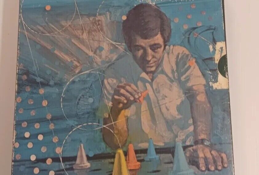 A worn-out board game cover for "CONTIGO" featuring artwork of a contemplative man positioning colorful game pieces on a grid with sailboats in the background. The tagline at the bottom reads, "Programmed moves add a new dimension to strategy games."