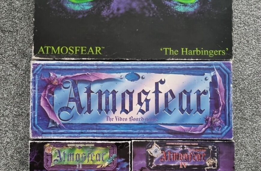 Alt text: A collection of "Atmosfear" board game boxes, including "The Harbingers" with glowing green eyes on the cover, and other editions featuring haunting imagery and promotional labels. The boxes appear slightly worn.
