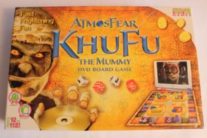 Board game titled "Atmosfear KHUFU THE MUMMY DVD BOARD GAME" by Vivid Games, depicting a mummy on the cover with a game board, DVD, and components shown on a yellow hieroglyphic background. Suitable for 3-6 players, ages 12 and up, with a playtime of under 60 minutes.