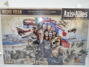 The image shows the board game box for "Axis & Allies: WWI 1914," a World War I strategy game. The box art features a collage of historical figures, military equipment, and flags from the WWI era, along with the game's title and branding.
