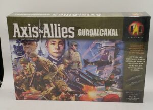 The board game box for "Axis & Allies Guadalcanal" by Avalon Hill, featuring illustrations of WWII military scenes including soldiers, naval ships, and aircraft, with prominent portraits of a Western and Asian military leader.
