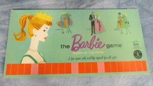 Vintage "The Barbie Game: Queen of the Prom" board game box featuring illustrated depictions of a young woman shopping, dating, and engaging in school activities, with a large portrait of Barbie on the left side, against a pale green background.