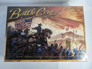Alt text: The image shows the box cover of "Battle Cry: 150th Civil War Anniversary Edition," a strategy board game by Richard Borg for 2 players aged 12+. The cover art features a dynamic Civil War battle scene with soldiers in blue uniforms, some on horseback, carrying the American flag, and a backdrop of a battlefield with flags and smoke.