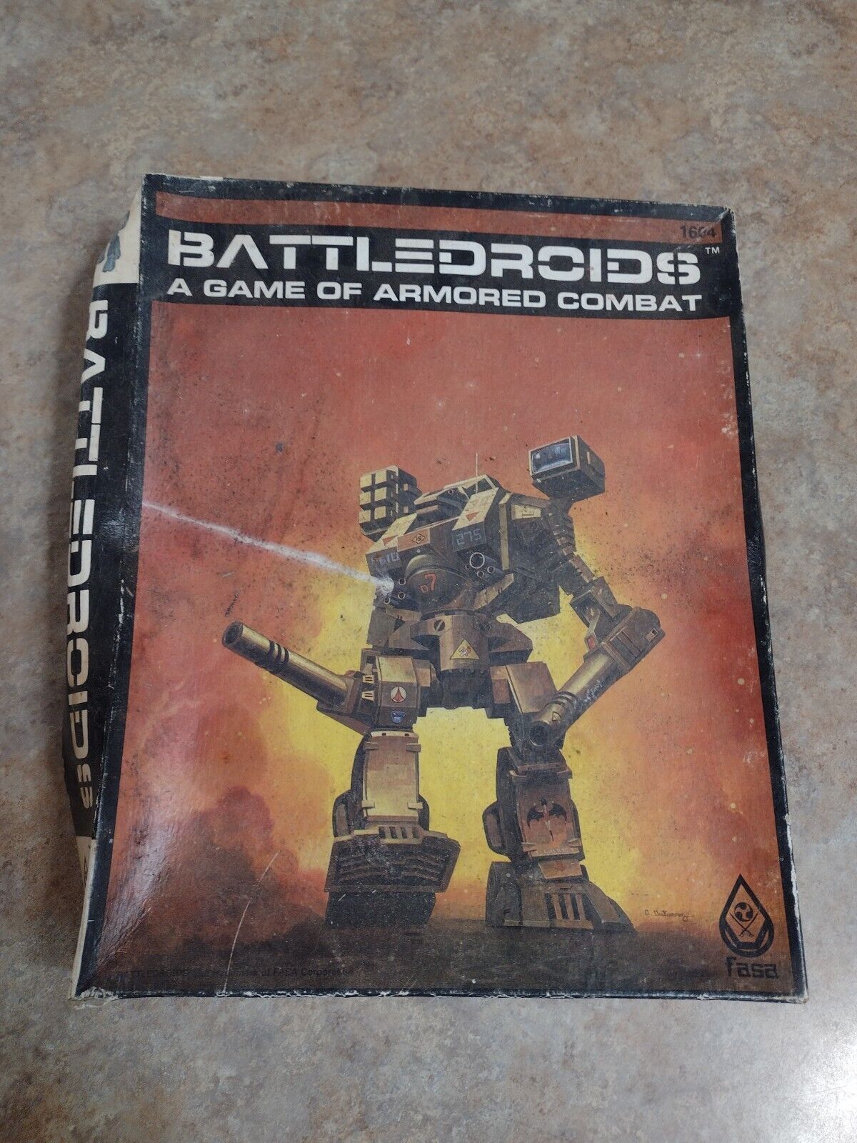 A worn copy of the "BATTLEDROIDS: A GAME OF ARMORED COMBAT" tabletop game box featuring a large robotic mech on a fiery backdrop. The FASA Corporation logo is visible in the bottom right corner.