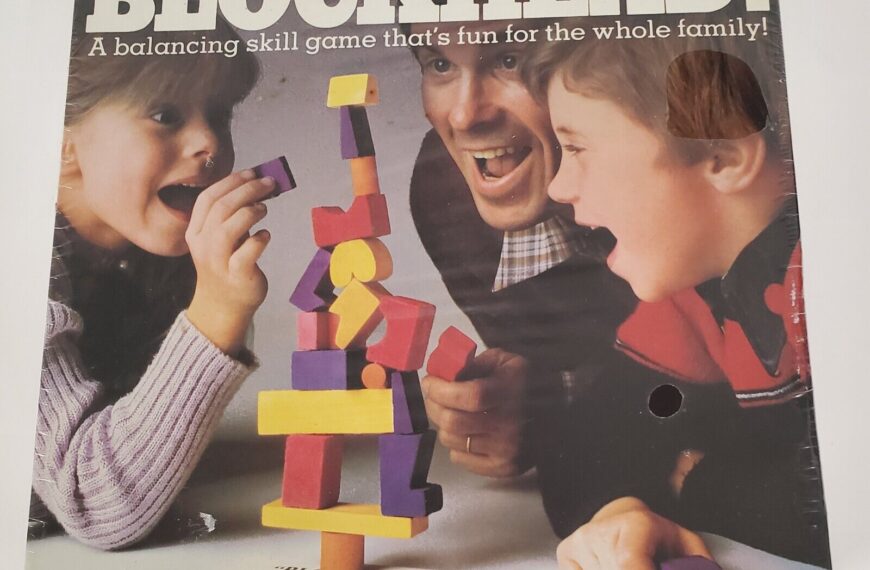 A vintage "BLOCKHEAD!" board game cover featuring two kids and an adult excitedly playing with a stack of colorful wooden blocks, with text indicating it is a balancing skill game for the whole family by Pressman.