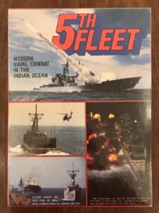 Box cover of "5th Fleet" board game, featuring images of modern naval combat in the Indian Ocean with military ships, a helicopter, and explosions at sea. Text includes the game's title, description, and publisher information (Victory Games Inc.).