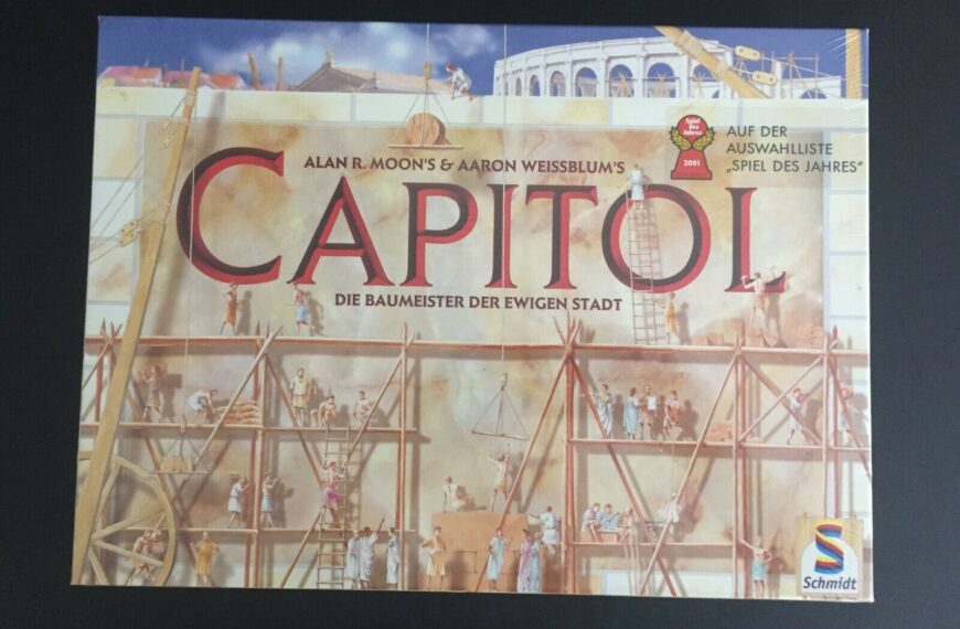 Board game cover for "CAPITOL" featuring an illustration of multiple people constructing classical Roman buildings with scaffolding, cranes, and the Colosseum in the background. Text includes the names "Alan R. Moon's & Aaron Weissblum's", "Die Baumeister der ewigen Stadt", and a label indicating "Spiel des Jahres" nominee for 2001. Schmidt Spiele logo is visible in the bottom right corner.