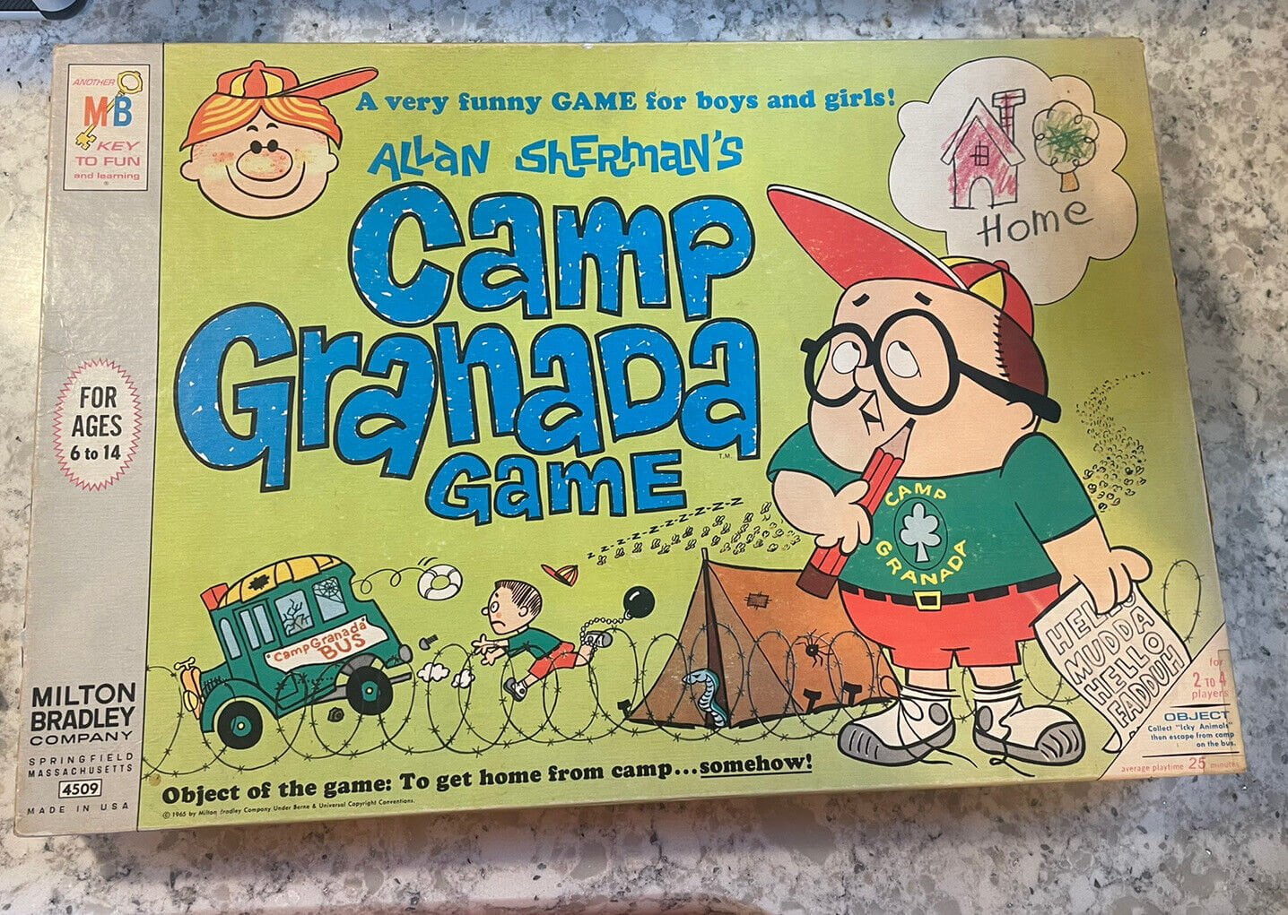 Vintage "Allan Sherman's Camp Granada Game" board game box cover featuring cartoon illustrations including a boy in camp attire with a thought bubble of a house labeled "Home," another child entangled in telephone wire, and a bus with "Camp Bunks" written on the side. Text on the box reads "A very funny GAME for boys and girls!," "For ages 6 to 14," "Milton Bradley Company Springfield Massachusetts," and "Object of the game: To get home from camp... somehow." The box shows signs of wear and a handwritten note.