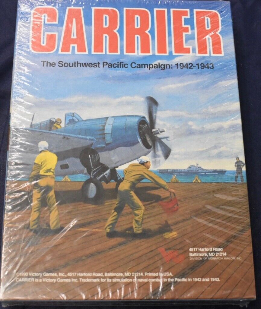 A shrink-wrapped board game titled "CARRIER The Southwest Pacific Campaign: 1942-1943" featuring an illustration of deck crew personnel in yellow attire preparing a blue military aircraft for takeoff on an aircraft carrier. The background shows a clear sky and another aircraft carrier in the distance. Visible on the cover is the publisher information "1990 Victory Games, Inc." with an address in Baltimore, Maryland, USA.