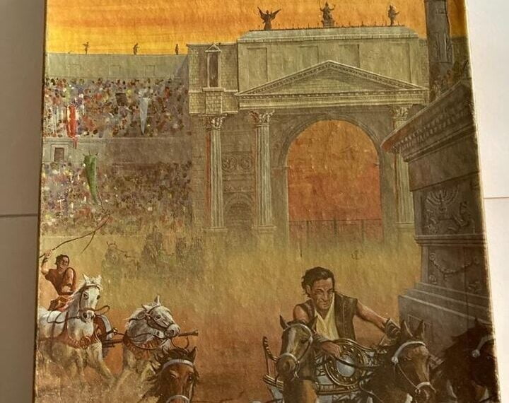 A weathered board game box for "CIRCUS MAXIMUS" featuring an illustration of a chariot race in ancient Rome, with charioteers driving horses amidst a large cheering crowd and classical Roman architecture in the background.