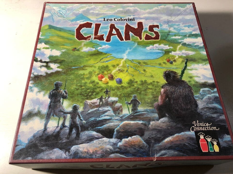 A board game box for "Clans" designed by Leo Colovini, featuring artwork of prehistoric figures standing on a rocky landscape looking out over a green valley with lakes and colorful tents, with the Venice Connection logo at the bottom right corner.