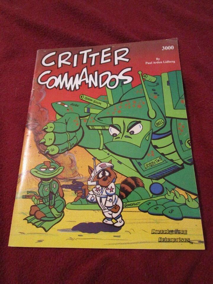The image shows the cover of a book titled "CRITTER COMMANDOS" with colorful cartoon illustrations of anthropomorphic animal soldiers in military outfits, including a prominent frog character in a green uniform with a helmet and a raccoon character in a white space suit with a gun. The book is authored by Paul Arden Lidberg and is part of the "3000" series by Crunchy Frog Enterprises.