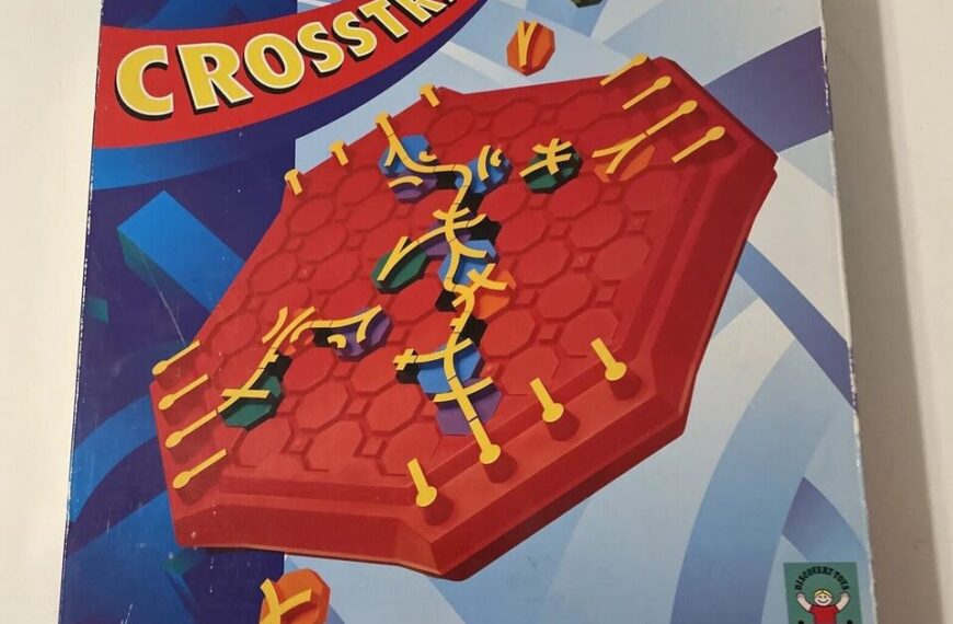 Box cover of the board game "Crosstrack," featuring a stylized depiction of a red hexagonal board with yellow tracks and multi-colored game pieces, set against a blue geometric background.