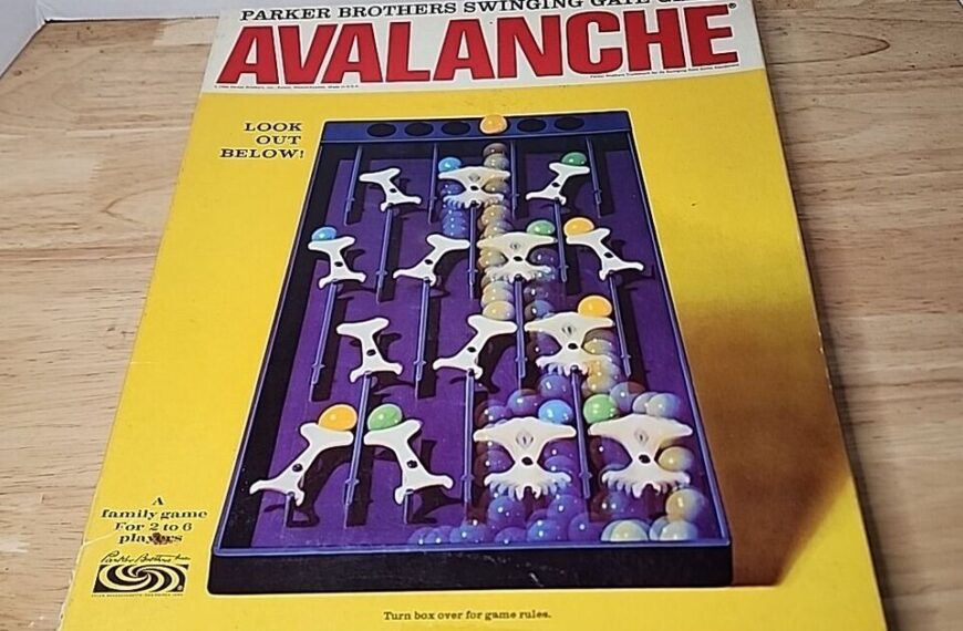 Old "Avalanche" board game by Parker Brothers, displayed in its original box with an image of the game in progress on the cover, placed on a wooden surface.