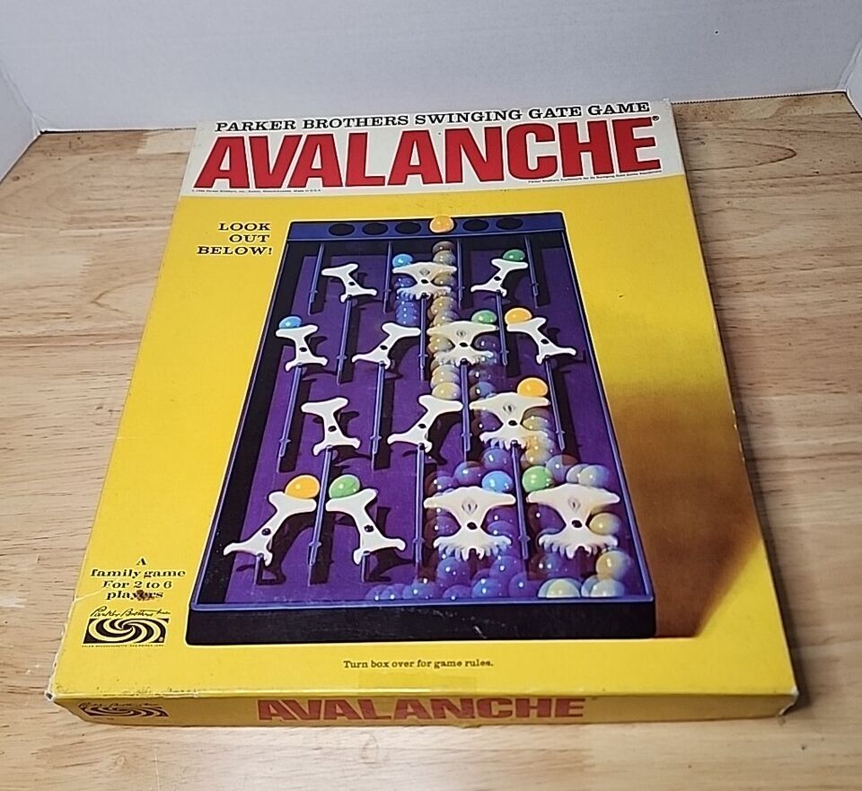 Old "Avalanche" board game by Parker Brothers, displayed in its original box with an image of the game in progress on the cover, placed on a wooden surface.