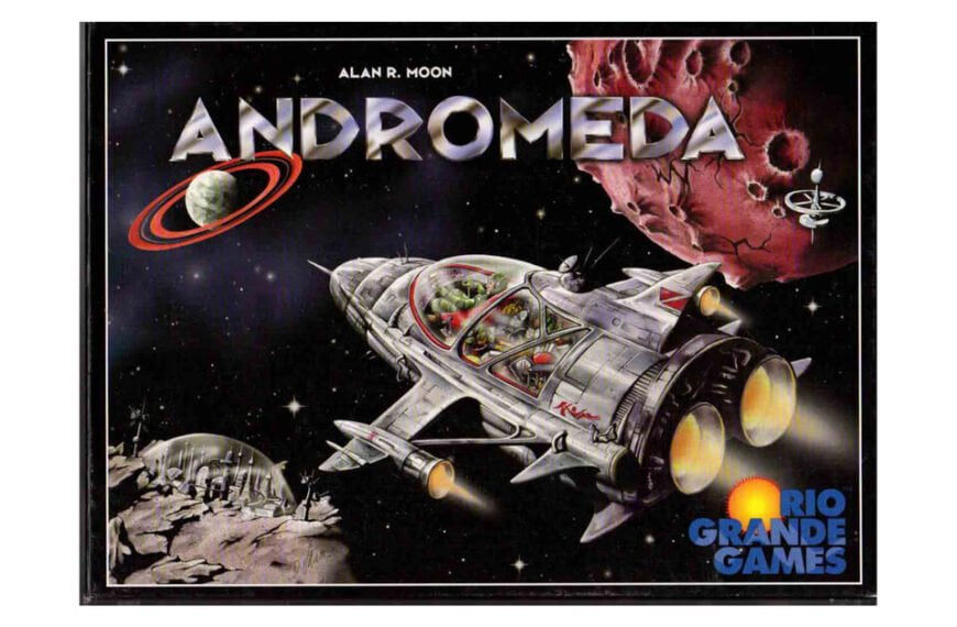 Box cover art for the board game "Andromeda" by Alan R. Moon, featuring a detailed illustration of a spaceship with a transparent dome revealing people inside, flying near a ringed planet and asteroid with the Rio Grande Games logo in the bottom right corner.