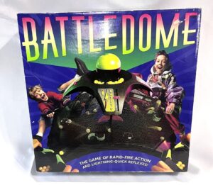 Box cover of "BATTLE DOME" game featuring images of excited children playing, with the dome and game pieces visible, and text describing it as "THE GAME OF RAPID-FIRE ACTION AND LIGHTNING-QUICK REFLEXES!"
