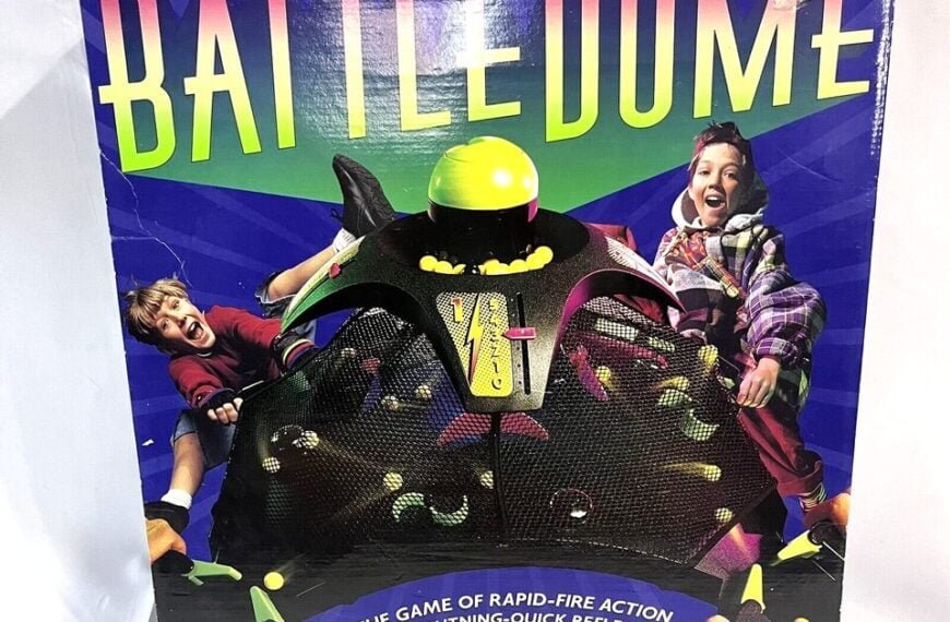 Box cover of "BATTLE DOME" game featuring images of excited children playing, with the dome and game pieces visible, and text describing it as "THE GAME OF RAPID-FIRE ACTION AND LIGHTNING-QUICK REFLEXES!"