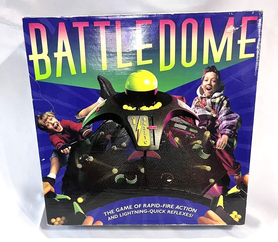 Box cover of "BATTLE DOME" game featuring images of excited children playing, with the dome and game pieces visible, and text describing it as "THE GAME OF RAPID-FIRE ACTION AND LIGHTNING-QUICK REFLEXES!"