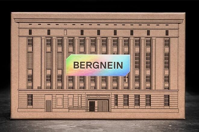 Cardboard model of a building with "BERGNEIN" overprinted in rainbow colors.