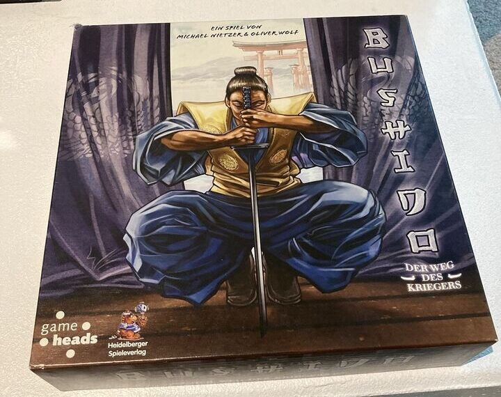 A boxed board game called "Bushido" featuring an illustrated samurai kneeling with a pair of swords crossed in front of him on the cover. The text includes the game designers' names and a tag from the publisher "Heidelberger Spieleverlag."