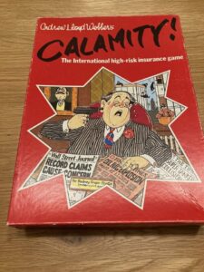 Board game box cover for "Andrew Lloyd Webber's CALAMITY! The International high-risk insurance game," featuring a cartoon illustration of a man in a suit with a startled expression holding insurance documents, as another man in the background points a gun at him. The box also includes newspaper-style headlines about record claims and oil rig explosions.