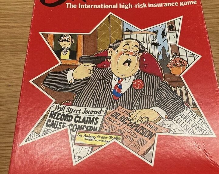 Board game box cover for "Andrew Lloyd Webber's CALAMITY! The International high-risk insurance game," featuring a cartoon illustration of a man in a suit with a startled expression holding insurance documents, as another man in the background points a gun at him. The box also includes newspaper-style headlines about record claims and oil rig explosions.